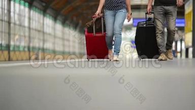 双脚带着行李箱在站台上行走，年轻夫妇带着行李箱沿着站台走到火车上